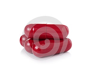 Red pill capsules on white background