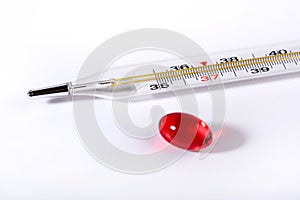 Red pill and thermometer on a white background, the concept of a flu epidemic. Copy space