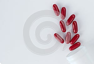 Red pills and capsules in a plastic bottle on a white background for use in presentations, manuals, design, etc. 3D illustration.