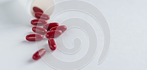 Red pills and capsules in a plastic bottle on a white background for use in presentations, manuals, design, etc. 3D illustration.