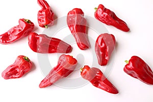 Red pimiento de Padron peppers isolated on white background. The peppers are customarily fried in olive oil until the skin starts