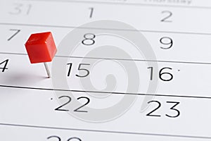 Red pin on a date on a calendar closeup. Important date. Place for text.