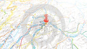 A red pin stuck in Bern on a map of Switzerland