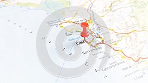 A red pin stuck in Cadiz on a map of Spain photo