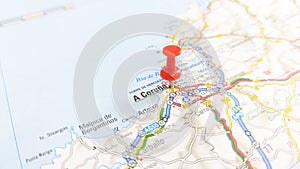 A red pin stuck in A Coruna on a map of Spain