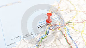 A red pin stuck in A Coruna on a map of Spain photo