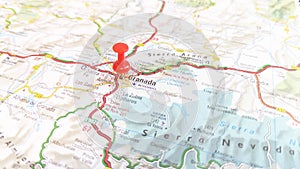 A red pin stuck in Grenada on a map of Spain photo