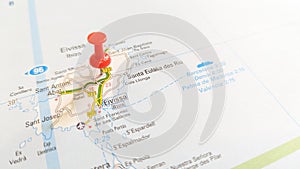 A red pin stuck in the island of Ibiza on a map of Spain