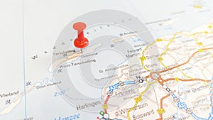 A red pin stuck in the island of Terschelling on a map of the Netherlands