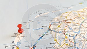 A red pin stuck in the island of Texel on a map of the Netherlands