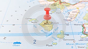 A red pin stuck in the Isle of Rum on a map of Scotland photo