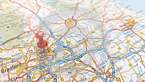 A red pin stuck in Leeds on a map of England photo