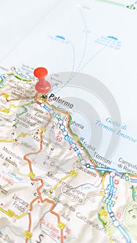 A red pin stuck in Palermo Sicily on a map of Italy portrait