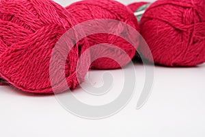 Red pink colorful skeins of yarn close up, fuchsia color woolen yarn for crochet and knitting, hobby and handmade concept, copu