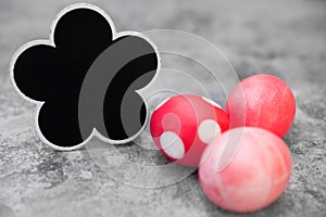 Red and pink easter eggs on grey background, flower shaped slate