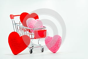 Red and Pink hearts in mini shopping cart falling on the background for valentines day. Top view and copy space