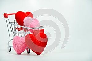 Red and Pink hearts in mini shopping cart falling on the background for valentines day. Top view and copy space