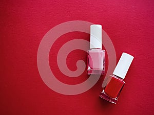 Red and pink nail polish bottles on red background, manicure and beauty cosmetics