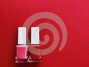 Red and pink nail polish bottles on red background, manicure and beauty cosmetics