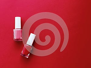 Red and pink nail polish bottles on red background, manicure and beauty cosmetics