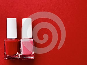 Red and pink nail polish bottles on red background, manicure and beauty cosmetics