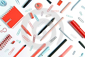 Red and pink office supplies including pens and paper clips photo