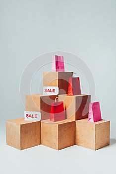 red and pink shopping bags with sale signs on wooden cubes, summer