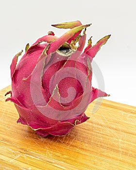 Red pitaya fruit. Red dragon fruit on a wooden cutting board on a white background