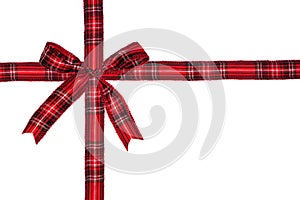 Red plaid Christmas gift bow and ribbon arranged as wrapped gift box isolated on white