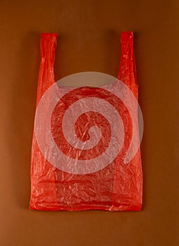 Red Plastic Bags on Brown Background, Crumpled Plastic Bag after Shopping, Cellophane Packaging Waste
