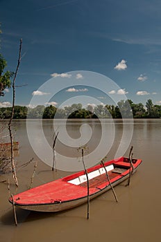 Red plastic boat floating on the river