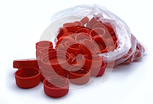 Red plastic bottle caps sorted by colors in transparent single use plastic bags. PP an PET pollution