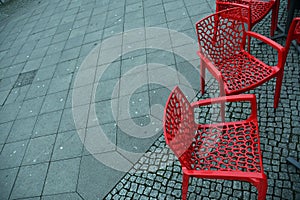 Red plastic chairs at streetside cafe