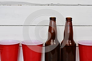 Red Plastic Drinking Cups and Two Beer Bottles