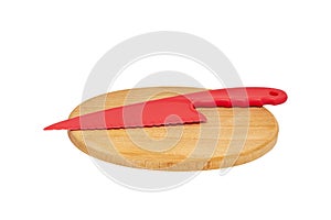 red plastic knife lies on an oval-shaped cutting board