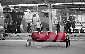 Red plastic seats on busy railway station platform