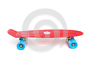 Red plastic skateboard on white background