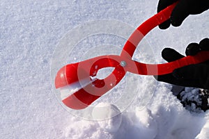 red plastic snowball maker on the white snow. The concept of winter holidays
