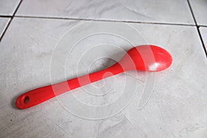 A red plastic spoon is upside down