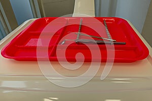 Red plastic tray with dental tools