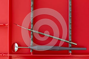 Red plastic tray with dental tools