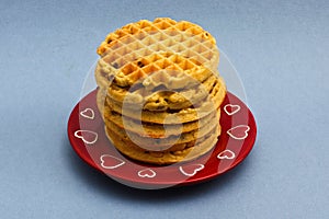 Red plate with blueberry wafles