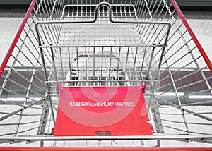 Red `PLEASE DON`T LEAVE CHILDREN UNATTENDED` Warning Sign on a Shopping Cart