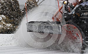 Red plow of a snowplow close up clearing snow off the road