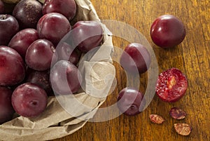 Red Plums in brown paper bag