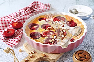 Red plums clafoutis flan with almonds, icing sugar dressing