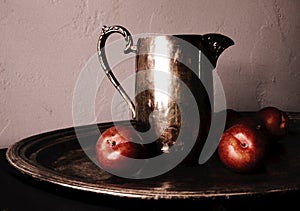 Red Plums on a Tarnished Silver Tray Beside a Tarnished Silver Pitcher