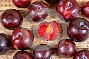 Red plums on wooden background photo