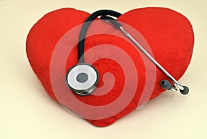 Red plush heart and stethoscope on the table