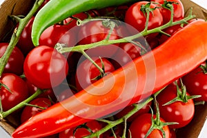 Red pod pepper on a background red cherry tomato on a branch close-up design vegetable bright